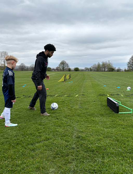 Coach working with a player on close control.